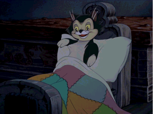 Animated cartoon of a cat tucked into bed grinning