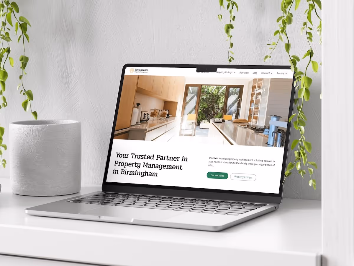 A property management website homepage shown on a laptop on a desk
