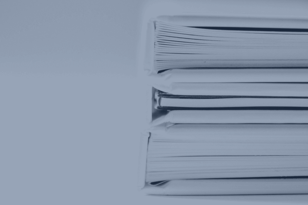 A tall stack of binders and paperwork
